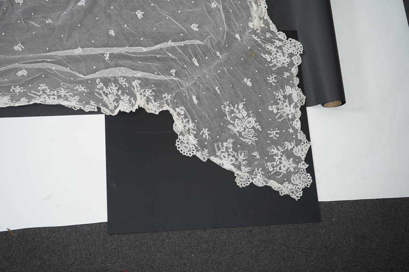 A late Edwardian hand bobbin lace Honiton and net wedding veil, approximately 248cm x 230cm. Condition - one corner has corner has been attached to a hair comb and damaged the netting.